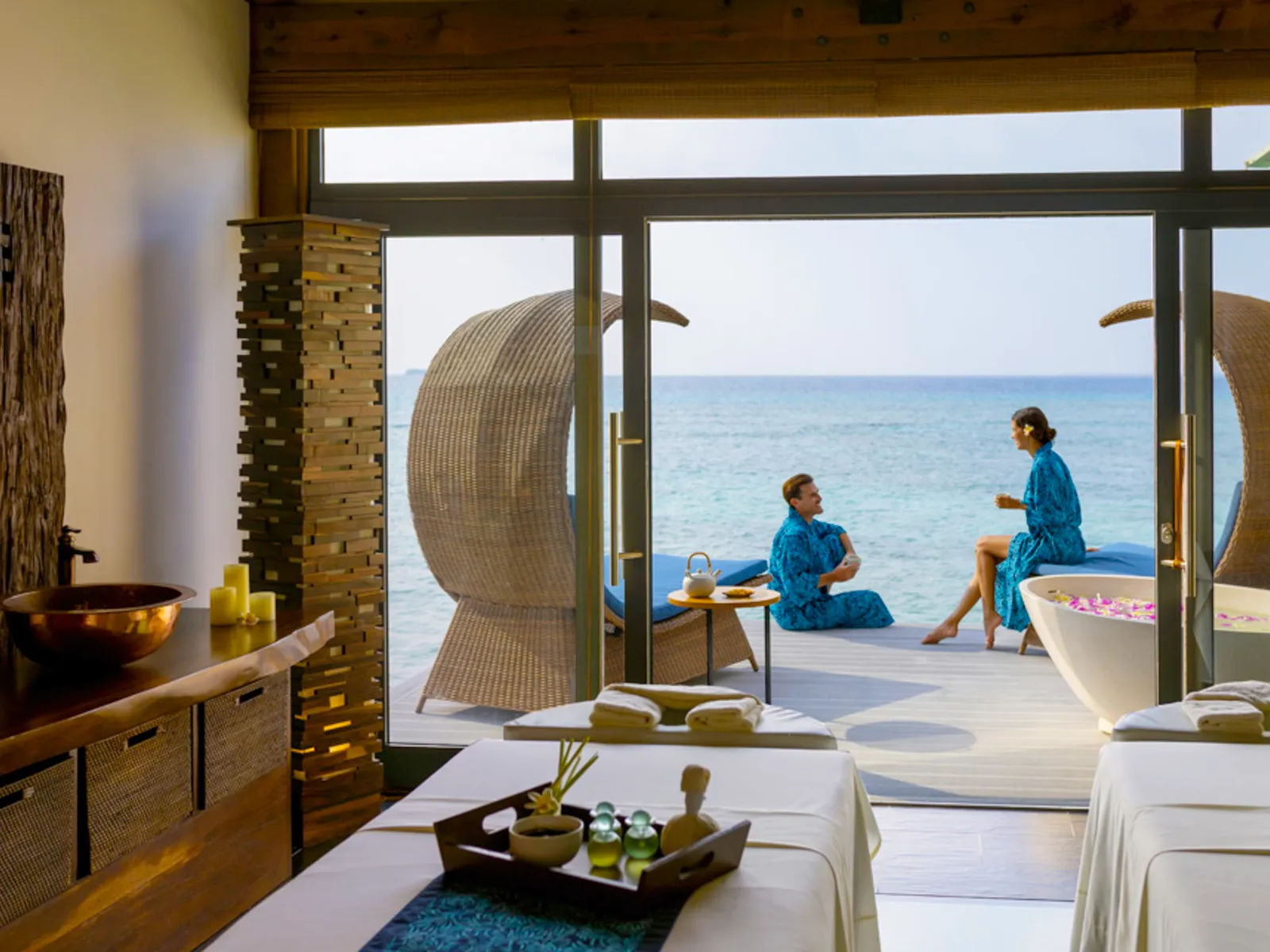 A Sun Spa room over the water, the beds and a couple on the deck