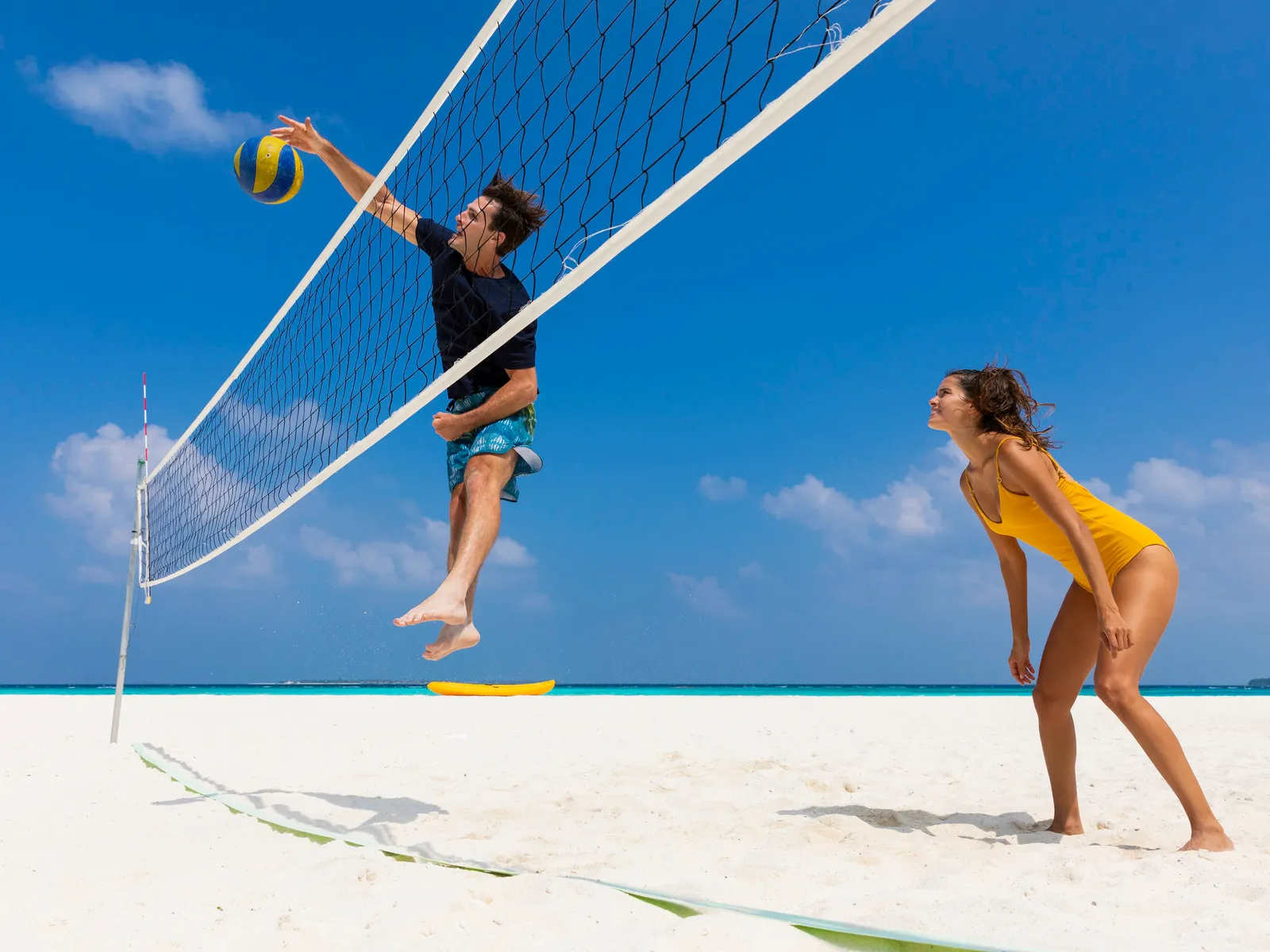 A game of beach volleyball on the white sand