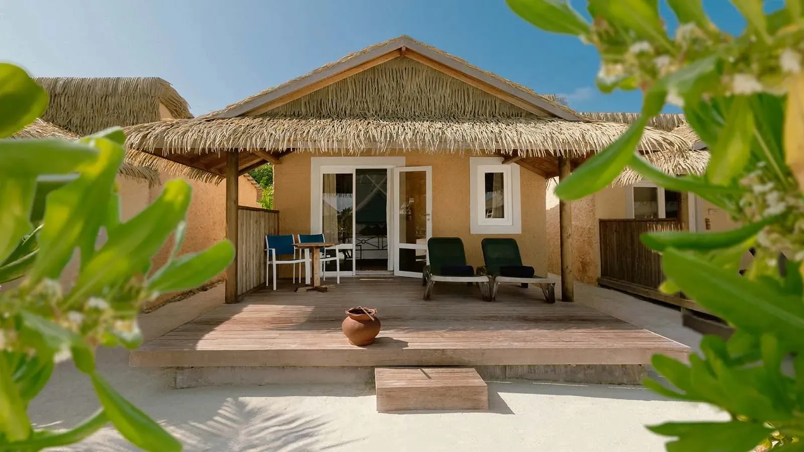 Garden Bungalow with a veranda and thatched roof among plants