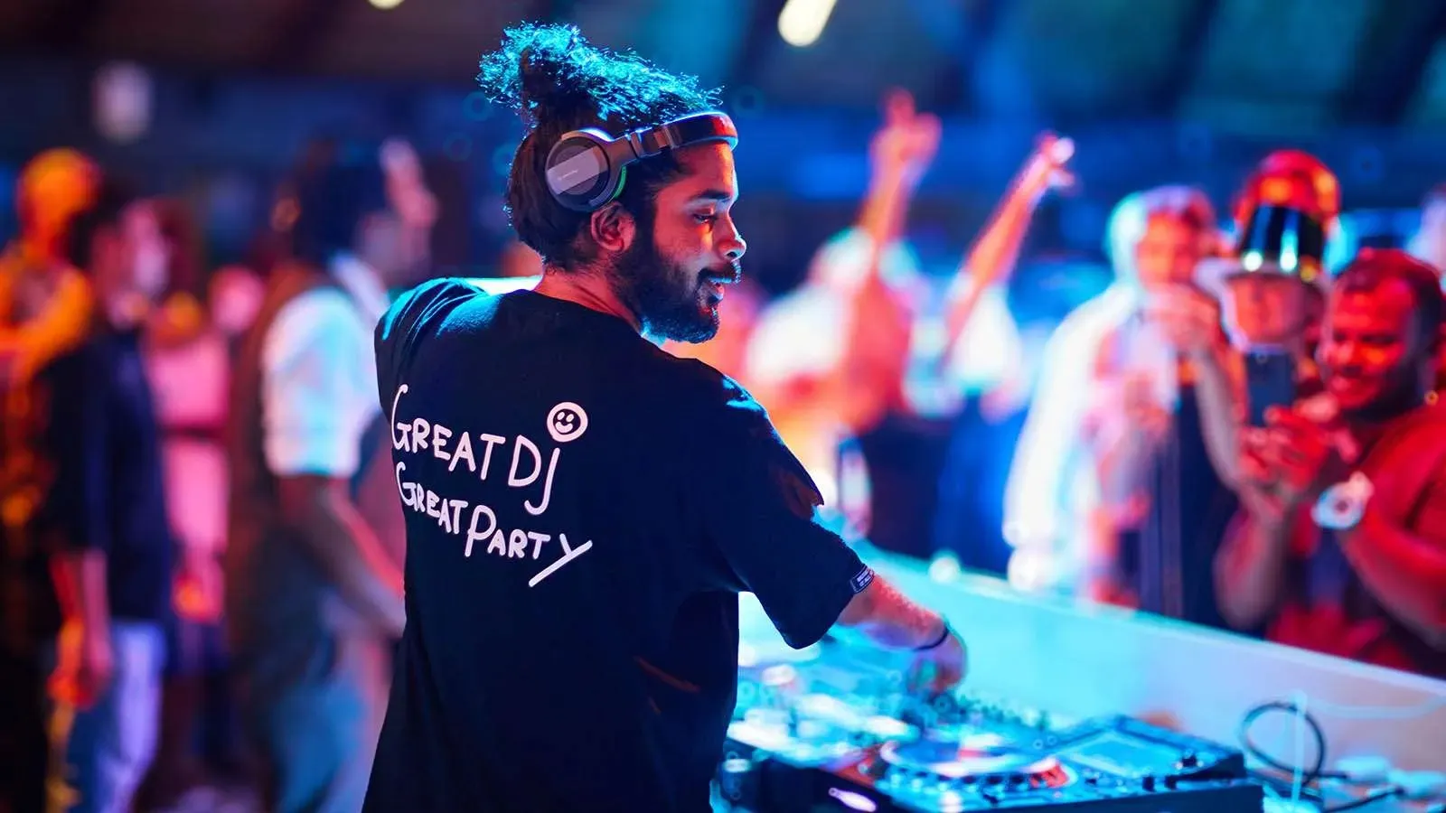 A DJ and guests at an evening party
