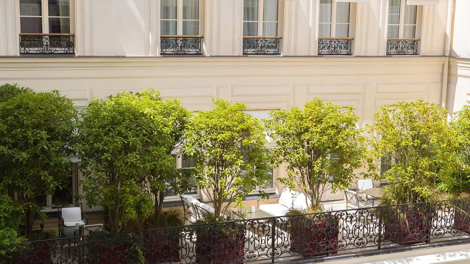 A terrace with a railing and plants overlooking the patio