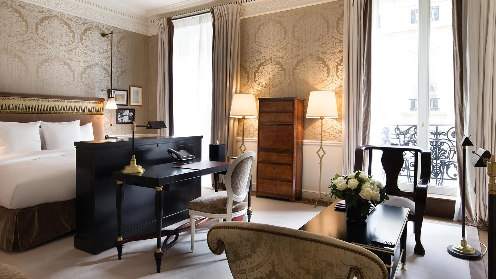 A bedroom with a bed, dark desk and window