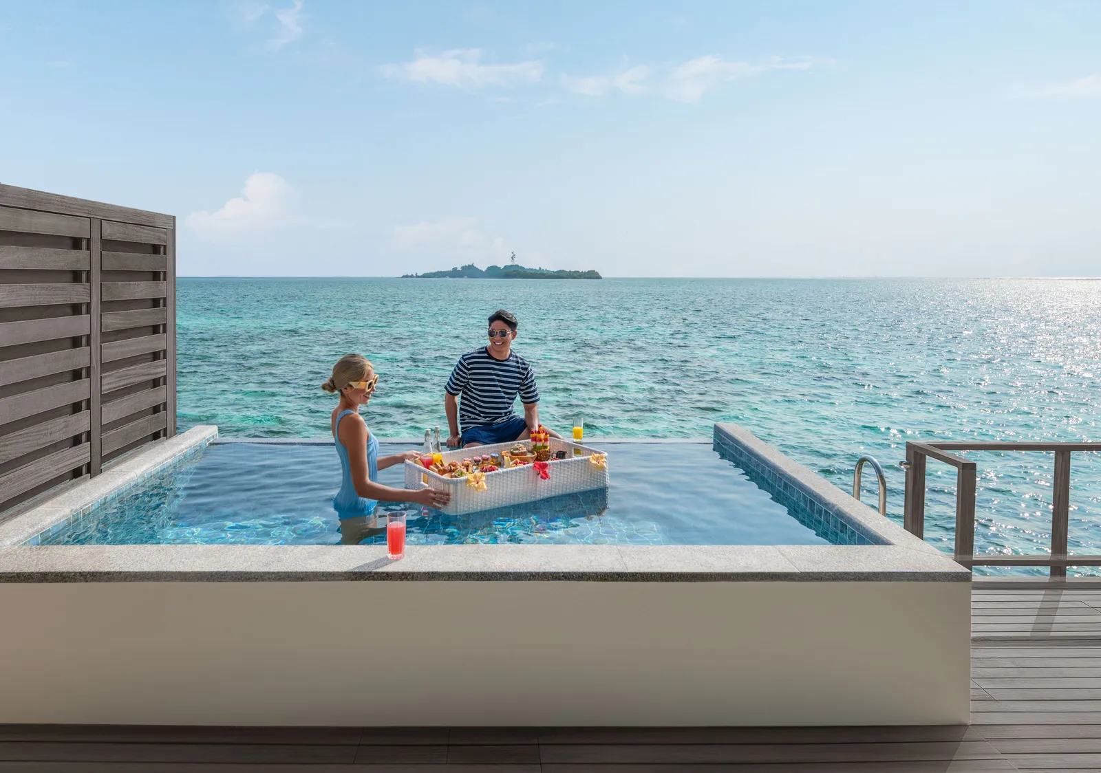 A floating breakfast in an overwater villa’s pool, the lagoon beyond the edge