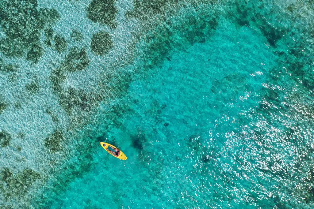 A yellow kayak over the lagoon’s turquoise water, seen from above