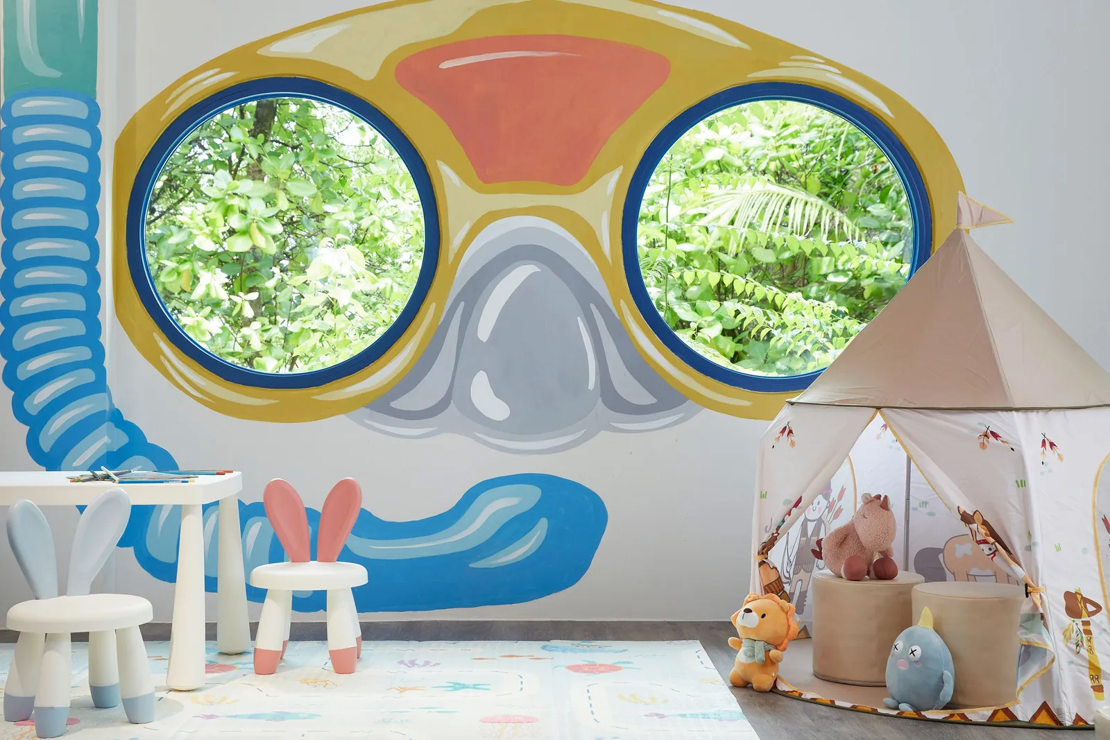 A Kids Hub room, a painted diving mask on the wall and a play tent