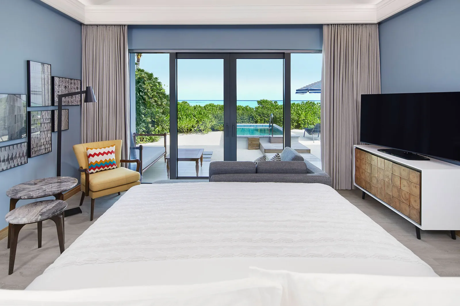 A Beach Pool Villa’s bedroom, the pool beyond the glass