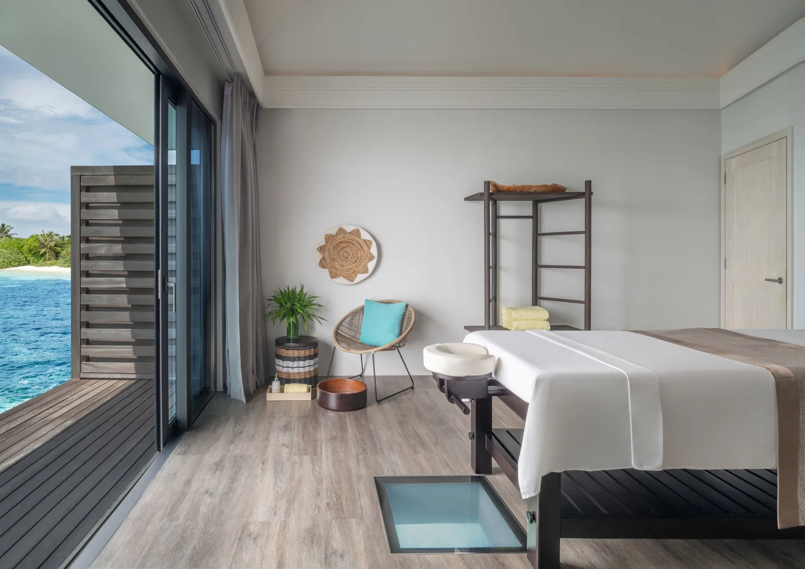 A spa treatment room, the bed beside the glass panel in the floor