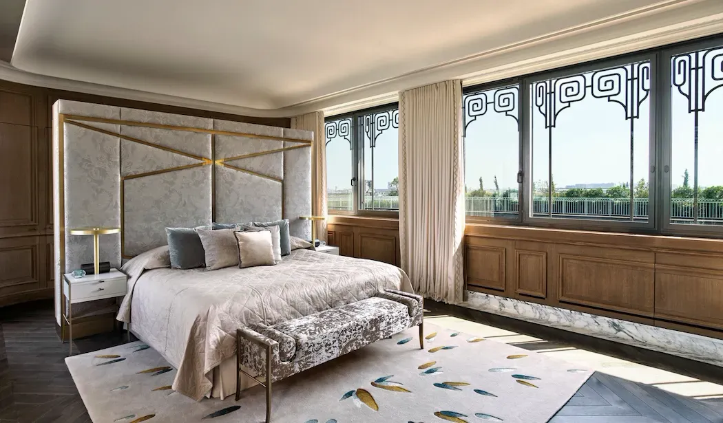 Belle Etoile Penthouse Suite with Terrace at Le Meurice, showing the main bedroom with a panelled headboard and a wall of large windows