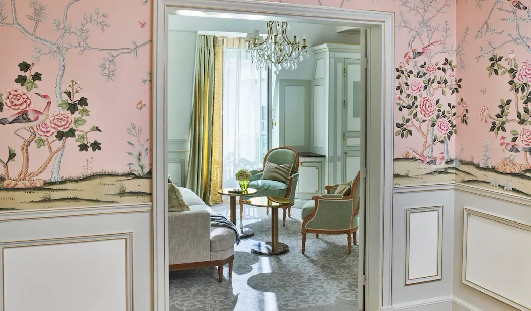 Executive Junior Suite at Le Meurice, with pink floral wall panels framing an open doorway into the sitting room