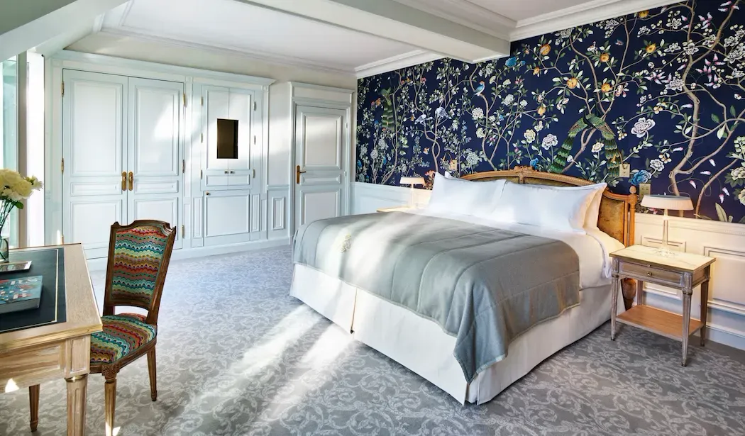 Executive Room, Eiffel View with Balcony at Le Meurice, with a blue floral wall behind the bed and pale green panelling