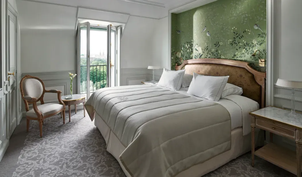 Superior Room, Eiffel View with Balcony at Le Meurice, with a green floral wall behind the bed and an open window