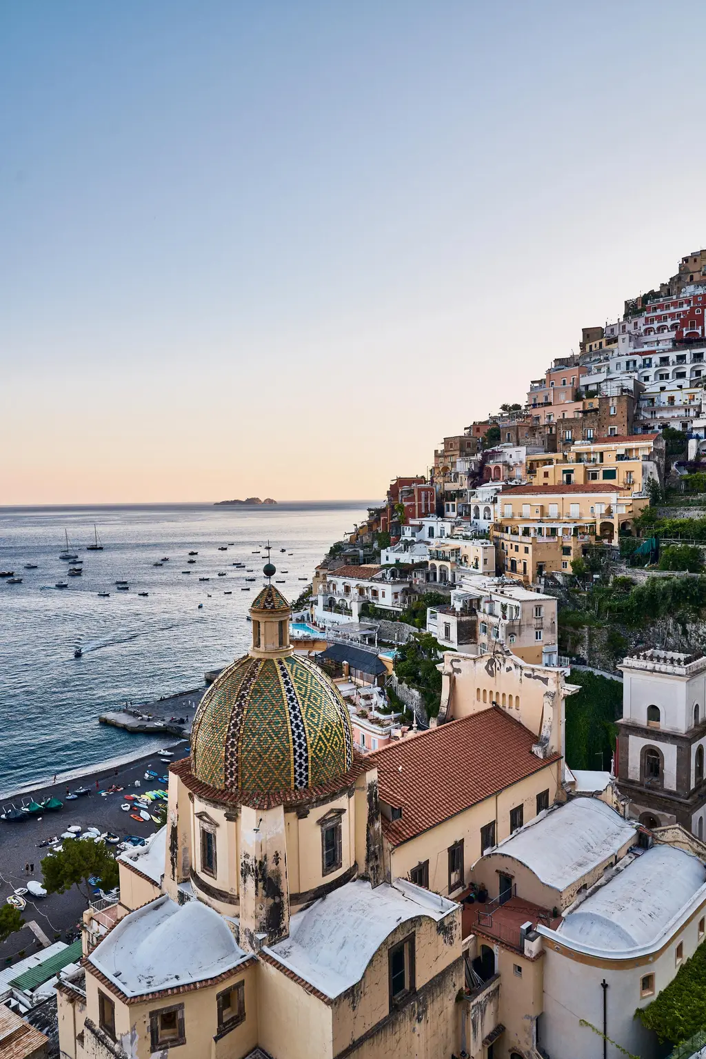 The dome of Santa Maria Assunta and the houses of Positano on the hillside, seen from the hotel at sunset.