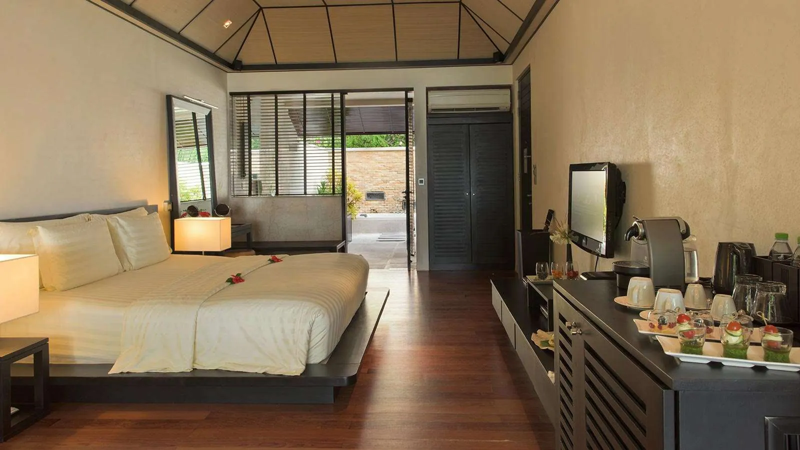 A Beach Villa bedroom, its bed and the door open to the terrace