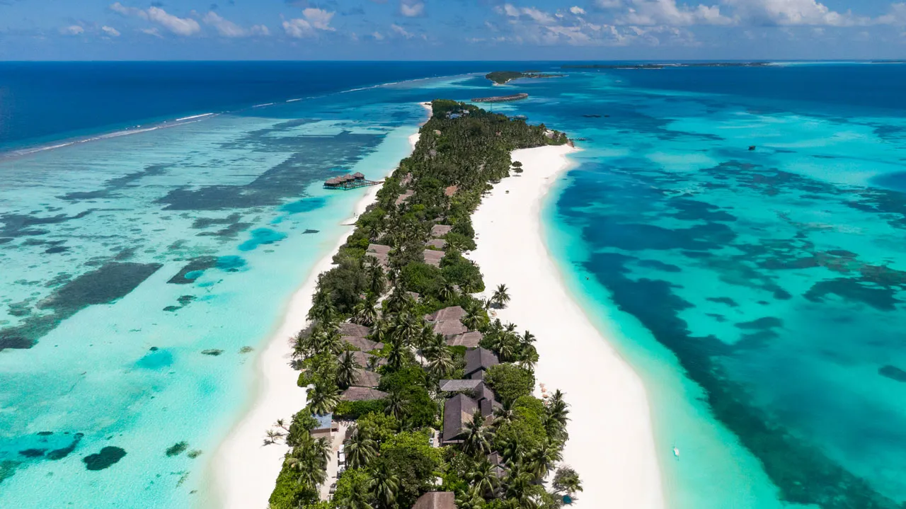 The island from the air, long and narrow, beach and lagoon on both sides