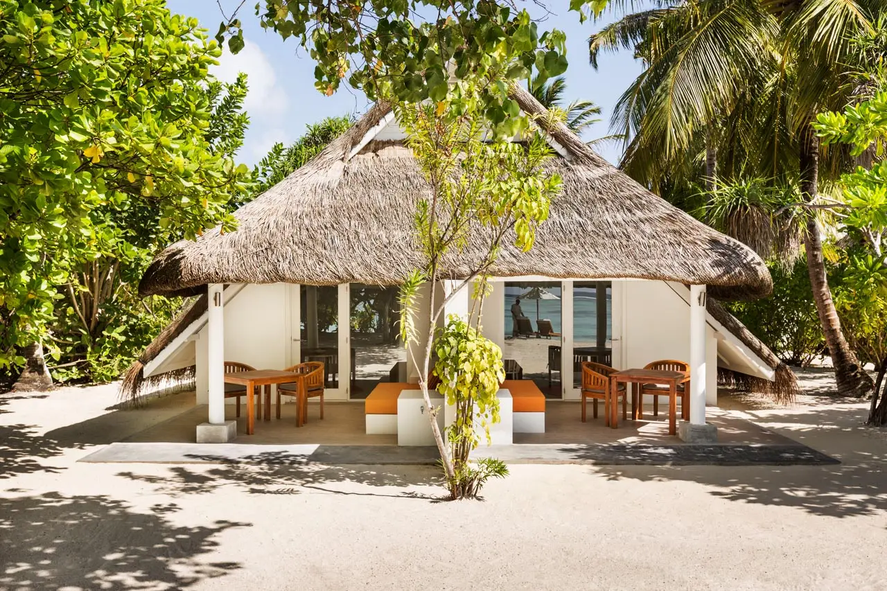A thatched Family Beach Pavilion, its terrace on the sand