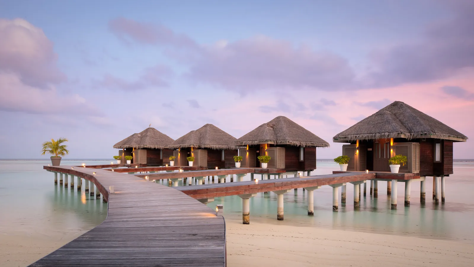 The LUX* ME Spa jetty and its treatment pavilions on the lagoon at dusk