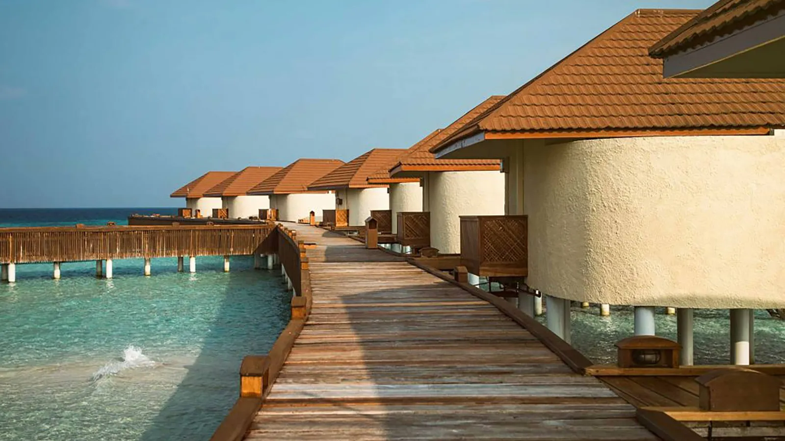 The timber walkway along the Over Water bungalows, their tiled roofs and decks above the lagoon.