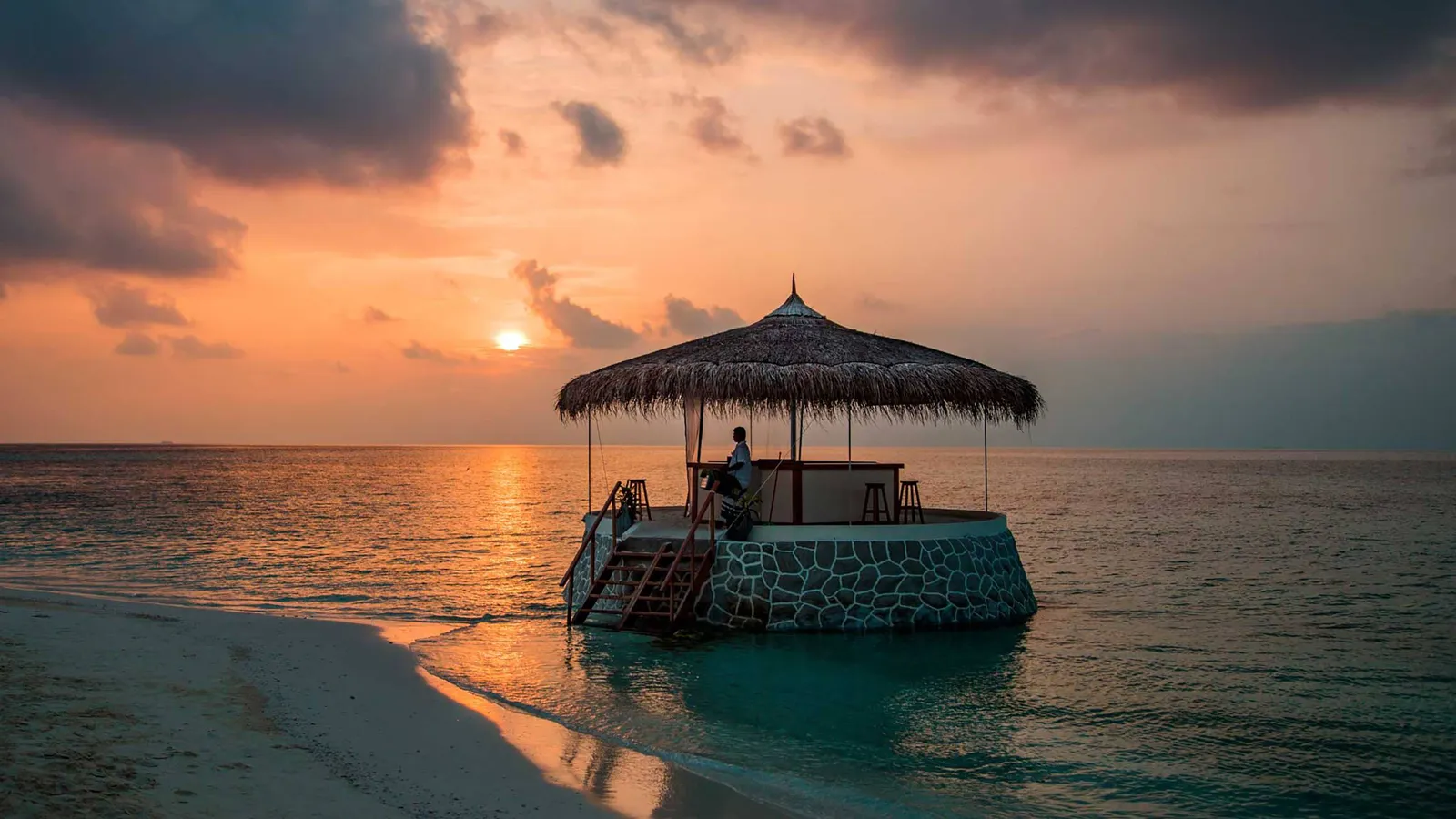 The Ocean Bar, a thatched pavilion on the sea where the sandbank begins, at sunset.