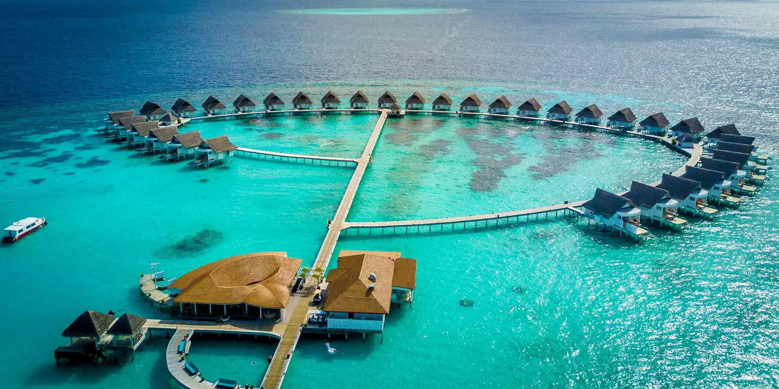 The ring of water villas from above, the long jetty crossing it and the bar pavilions in the foreground.