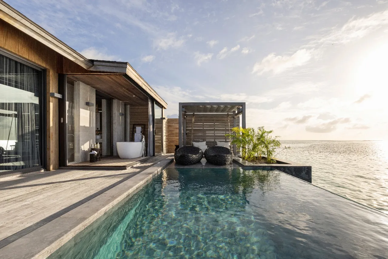 A Sunset Aqua Pool Villa’s infinity pool, the timber villa to the left and the open sea ahead.