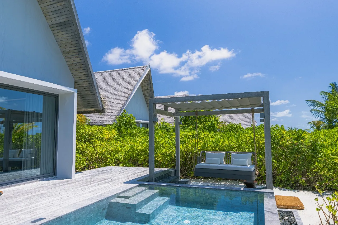 A Sunset Serene Pool Villa’s terrace, with its pool, the swing under the pergola and greenery around it.