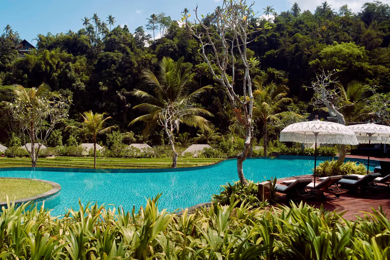 The main pool beside the resort’s rice terraces, with white parasols and the hills beyond