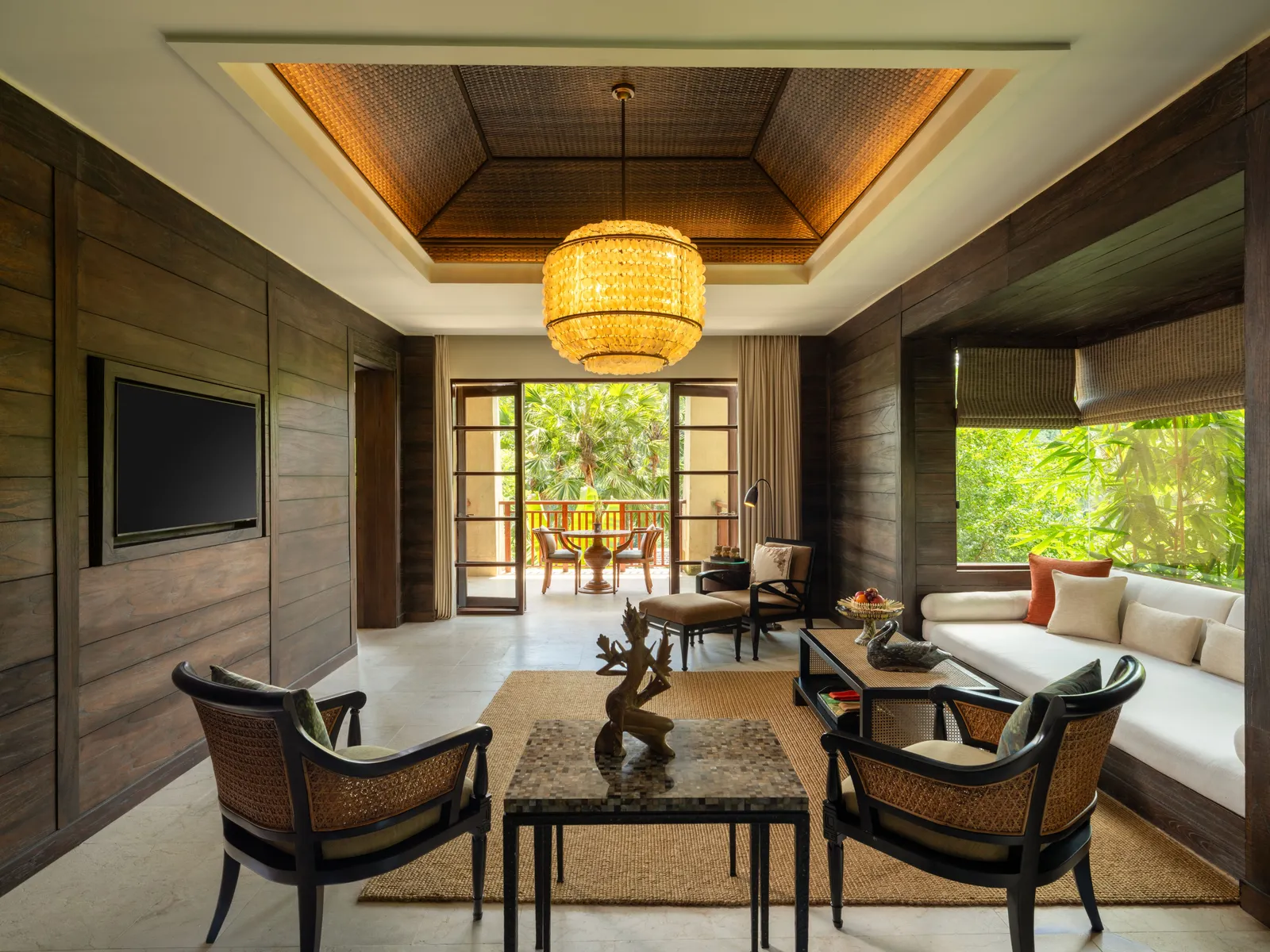 The living room of a Mandapa Suite, the corner suite, its sofa facing the windows