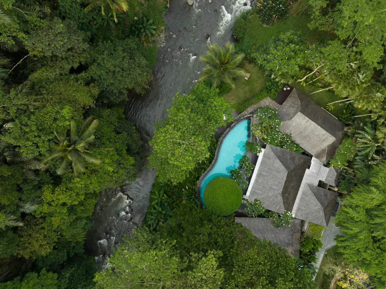 The Reserve Pool Villa from above: thatched roofs, the pool and the forest round it