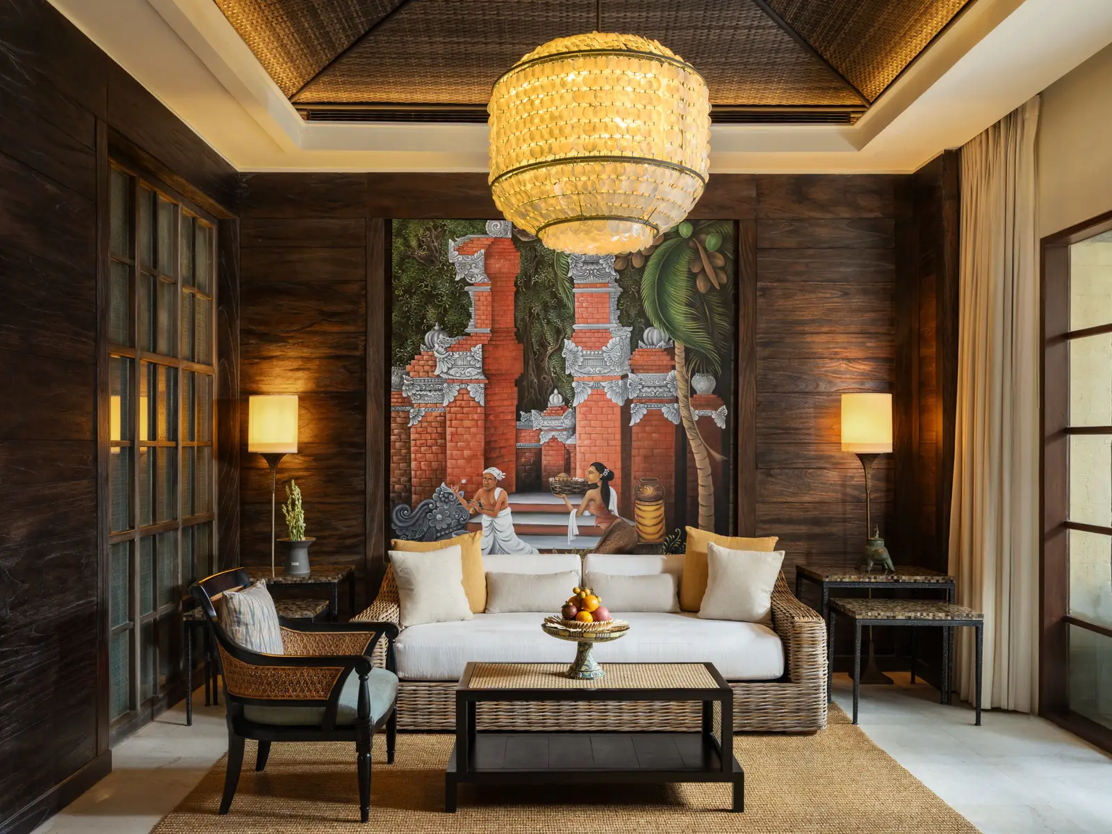 The living room of a Reserve Suite, its sofa before a painted panel