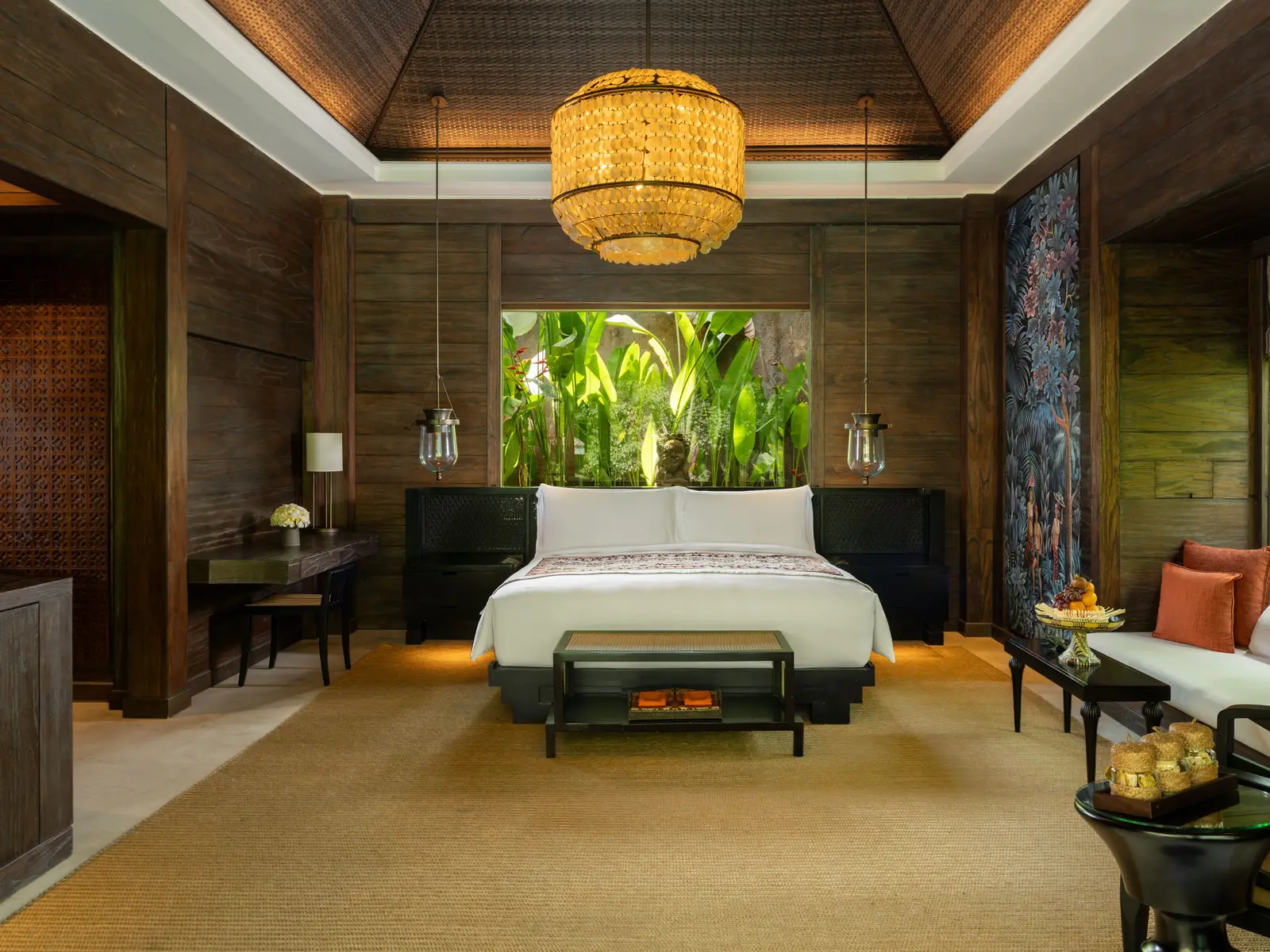 The bedroom of an Ubud Pool Villa, its king bed and doors on the garden