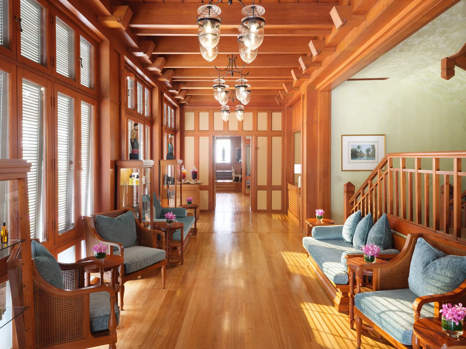 La reception di The Oriental Spa nella casa di teak: pavimenti lucidi, lanterne e poltrone azzurre