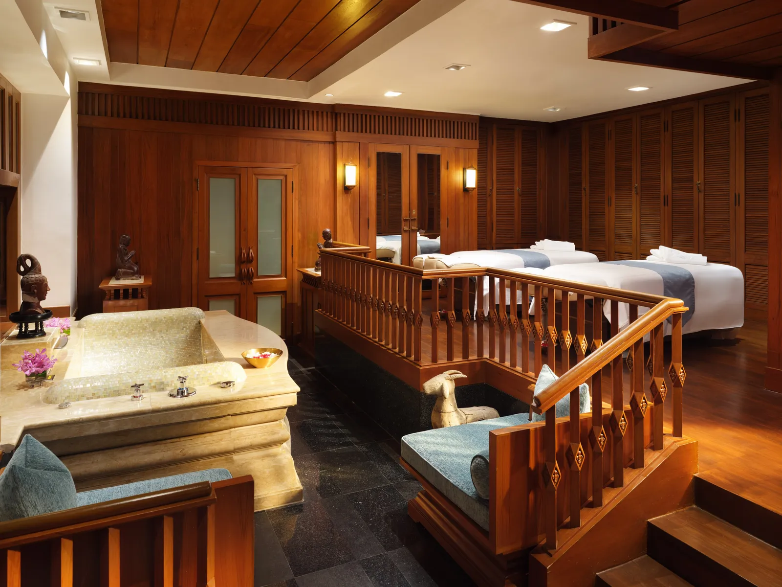 Una suite della spa in teak, con 2 lettini e una vasca di pietra