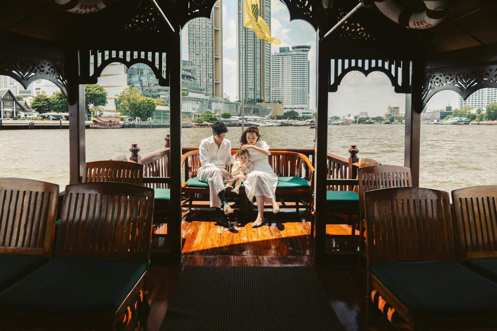 Una famiglia a bordo di una barca di teak dell’hotel sul Chao Phraya