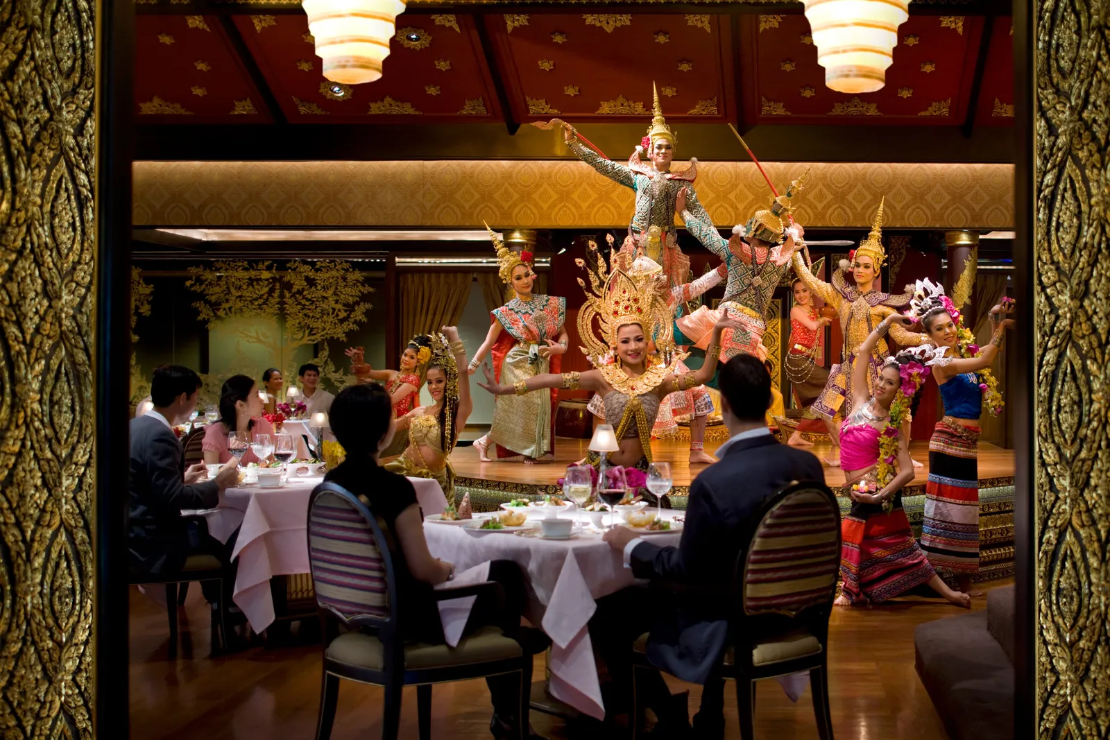 Ospiti a cena a Sala Rim Naam davanti a danzatori thai in costume d’oro