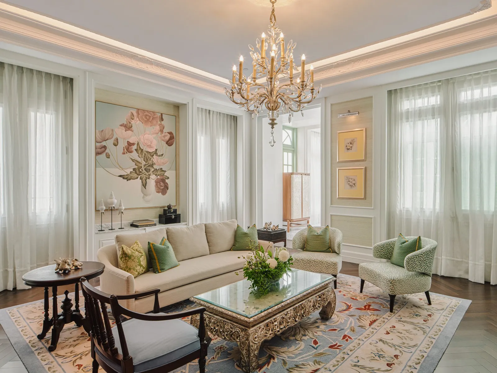 Ambassador Suite: un divano color crema, poltrone verdi e un lampadario d’ottone