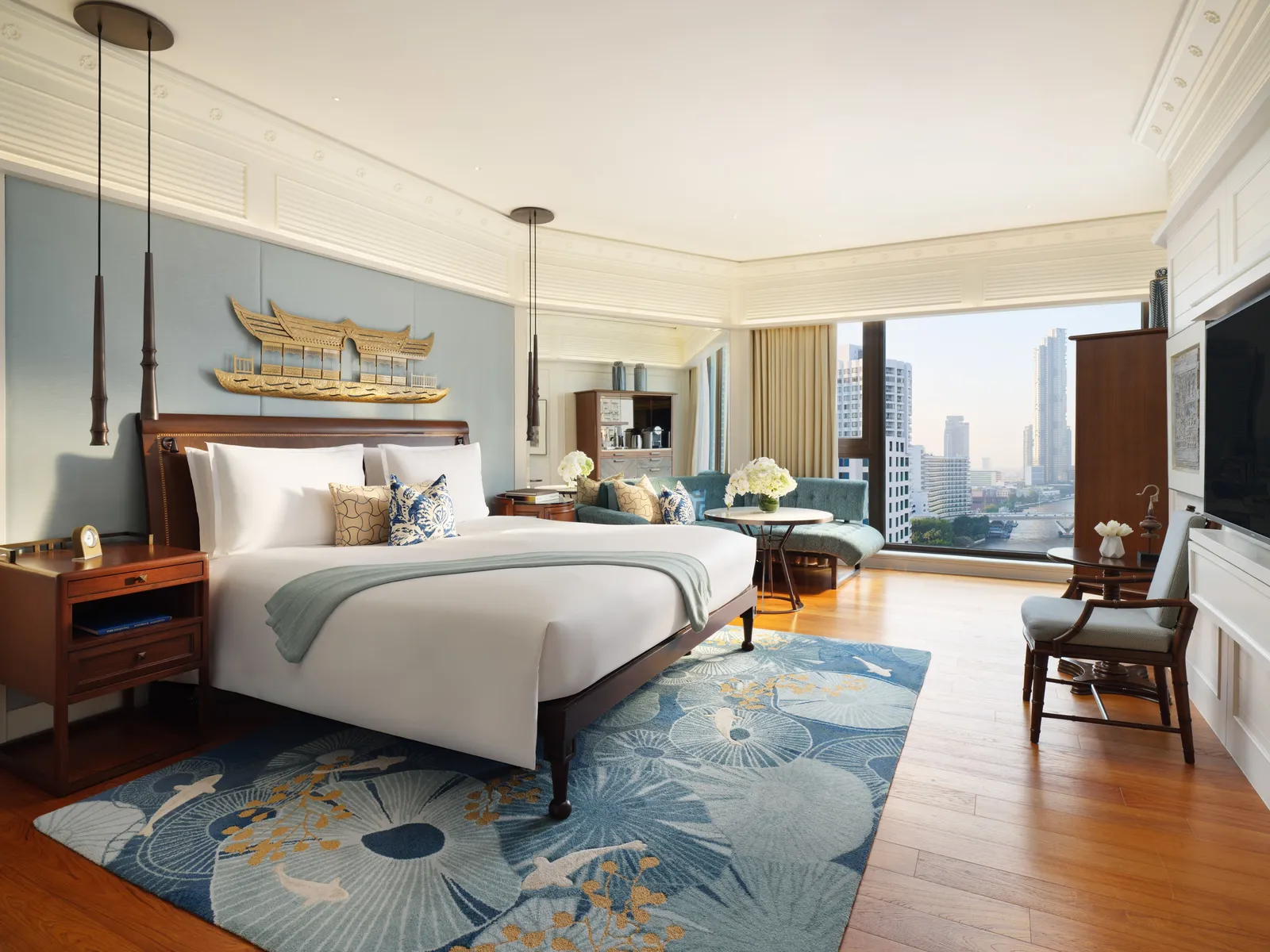 Deluxe Premier Room: letto king, un tappeto azzurro a fiori di loto e il fiume oltre le vetrate