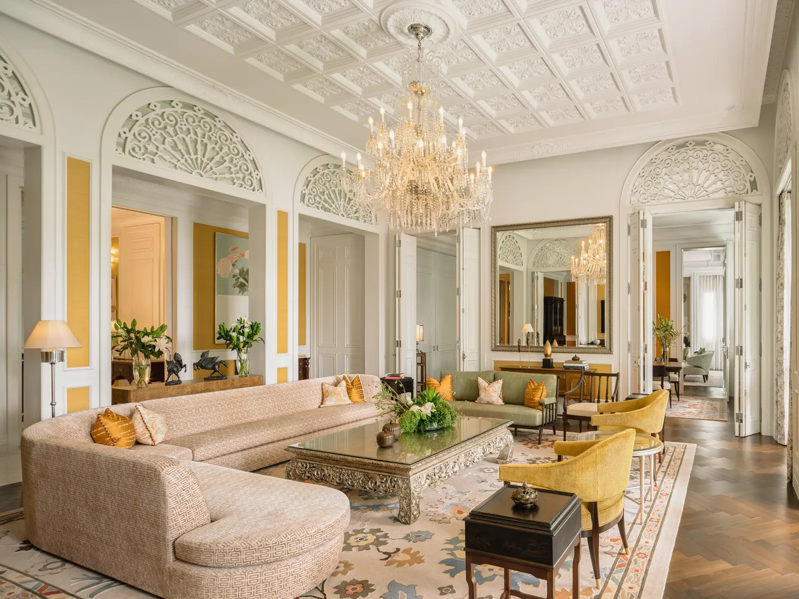 Royal Suite: sedute curve color crema, specchi dorati e un lampadario di cristallo
