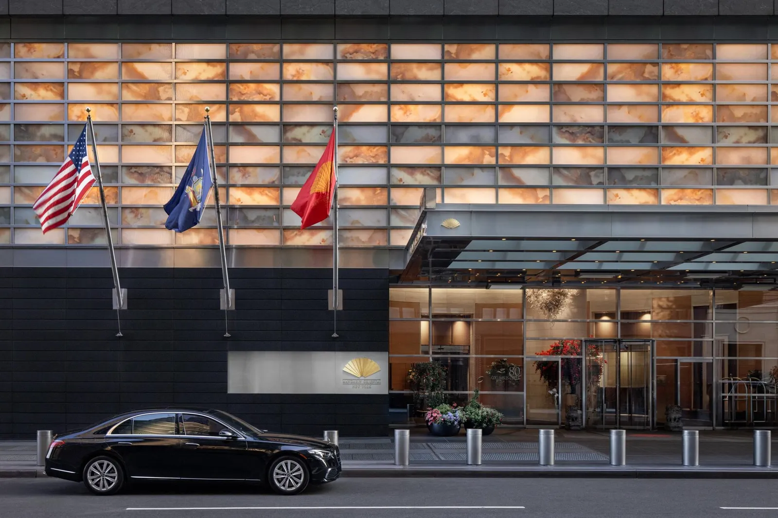 Ingresso dell’hotel su strada, con bandiere e pensilina di vetro