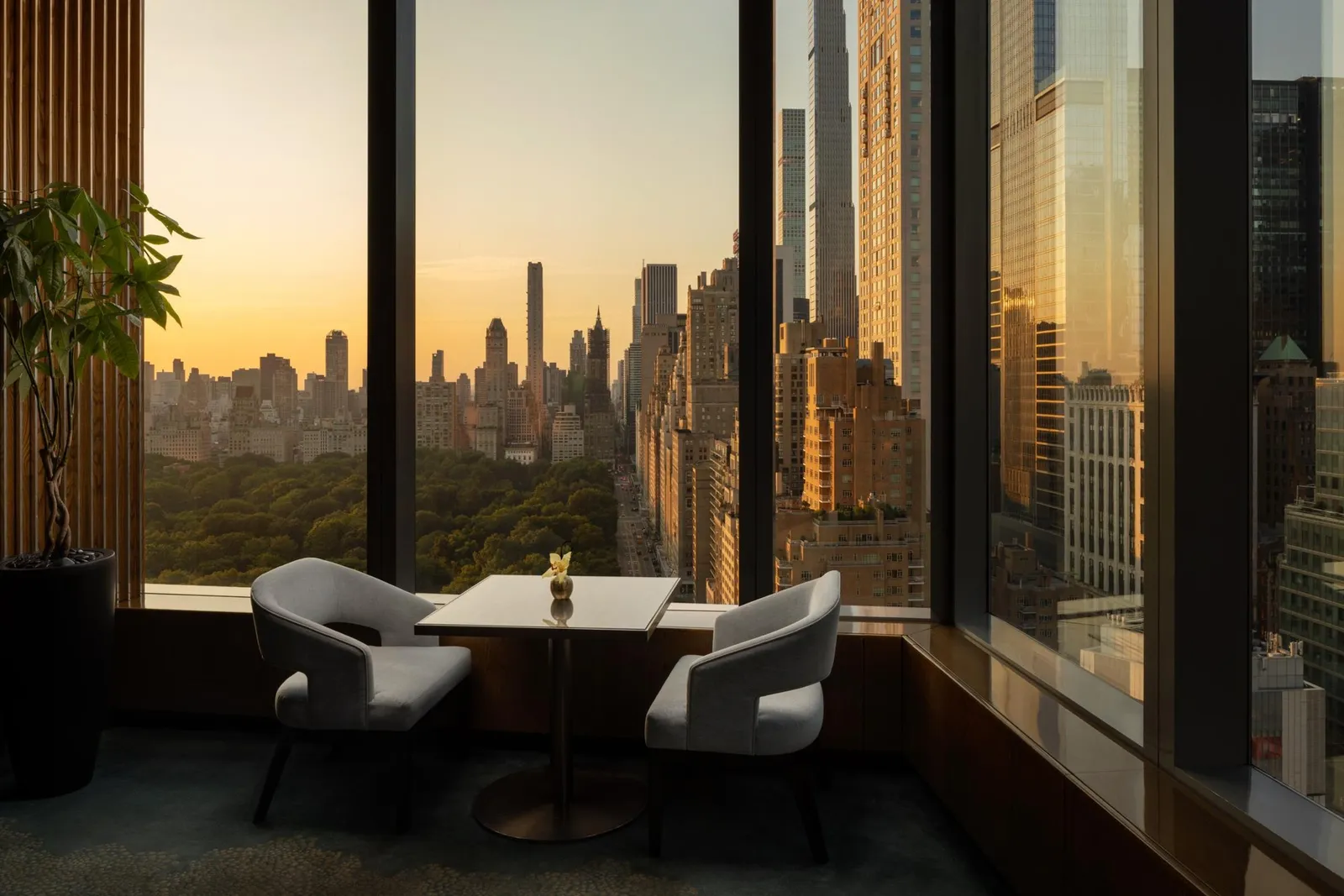 A MO Lounge table beside the windows towards Central Park at sunset
