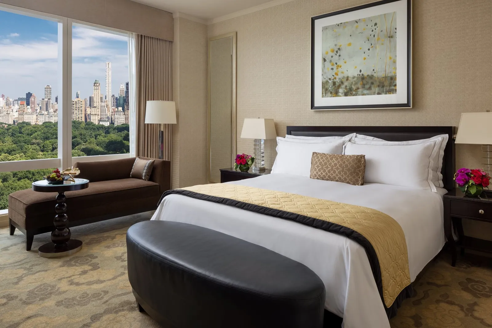 King bed with gold cushions and a view towards the park