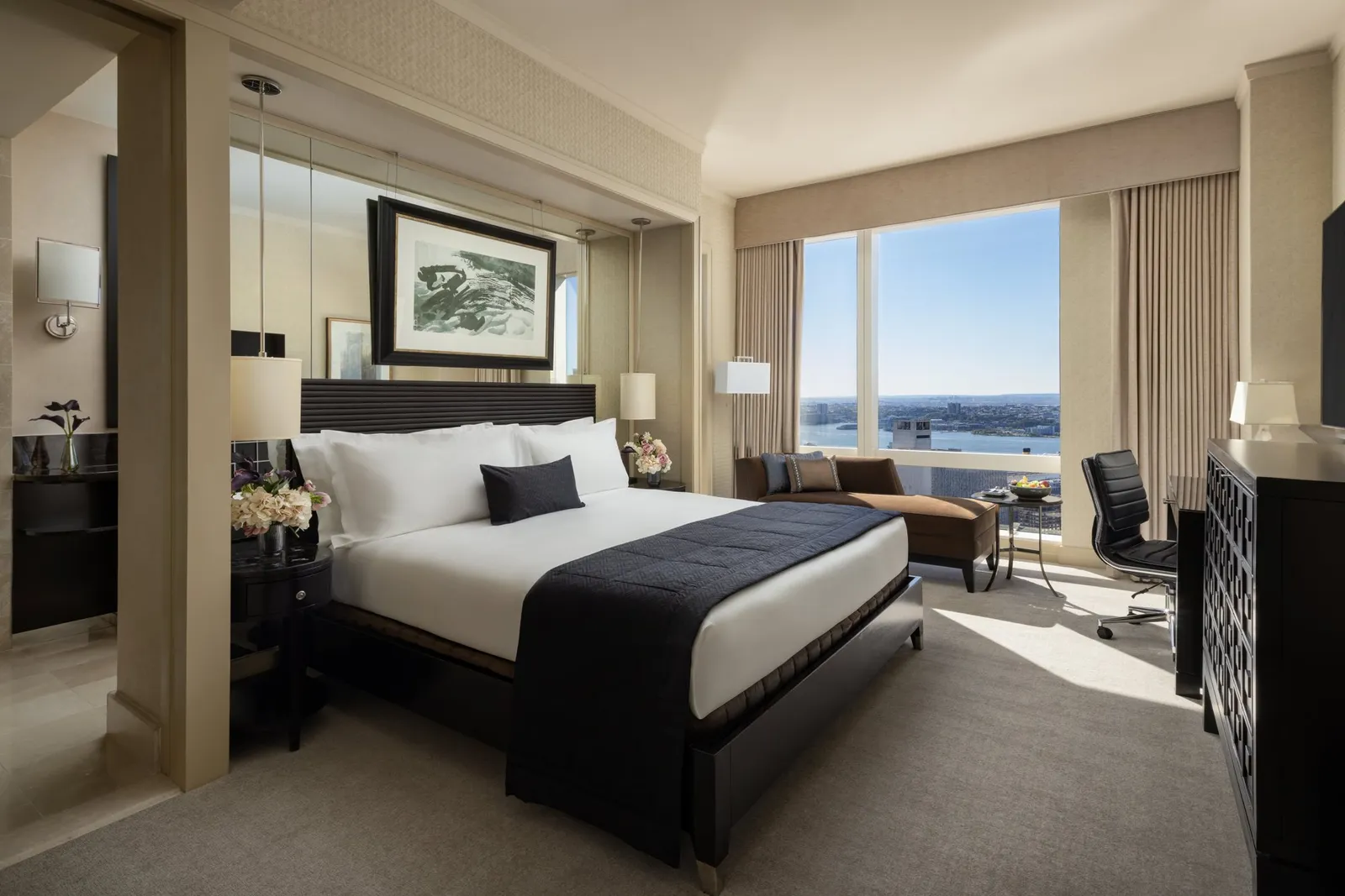 King bed, chaise longue and desk beside a river-facing window