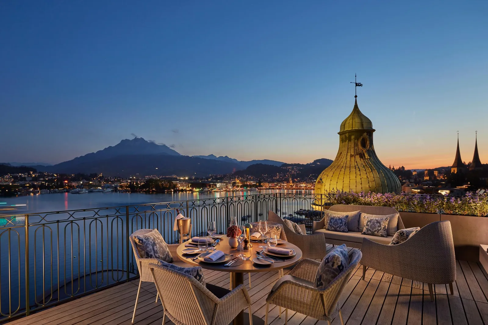 La terrazza della Panoramic Rooftop Terrace Suite apparecchiata al tramonto, davanti al lago