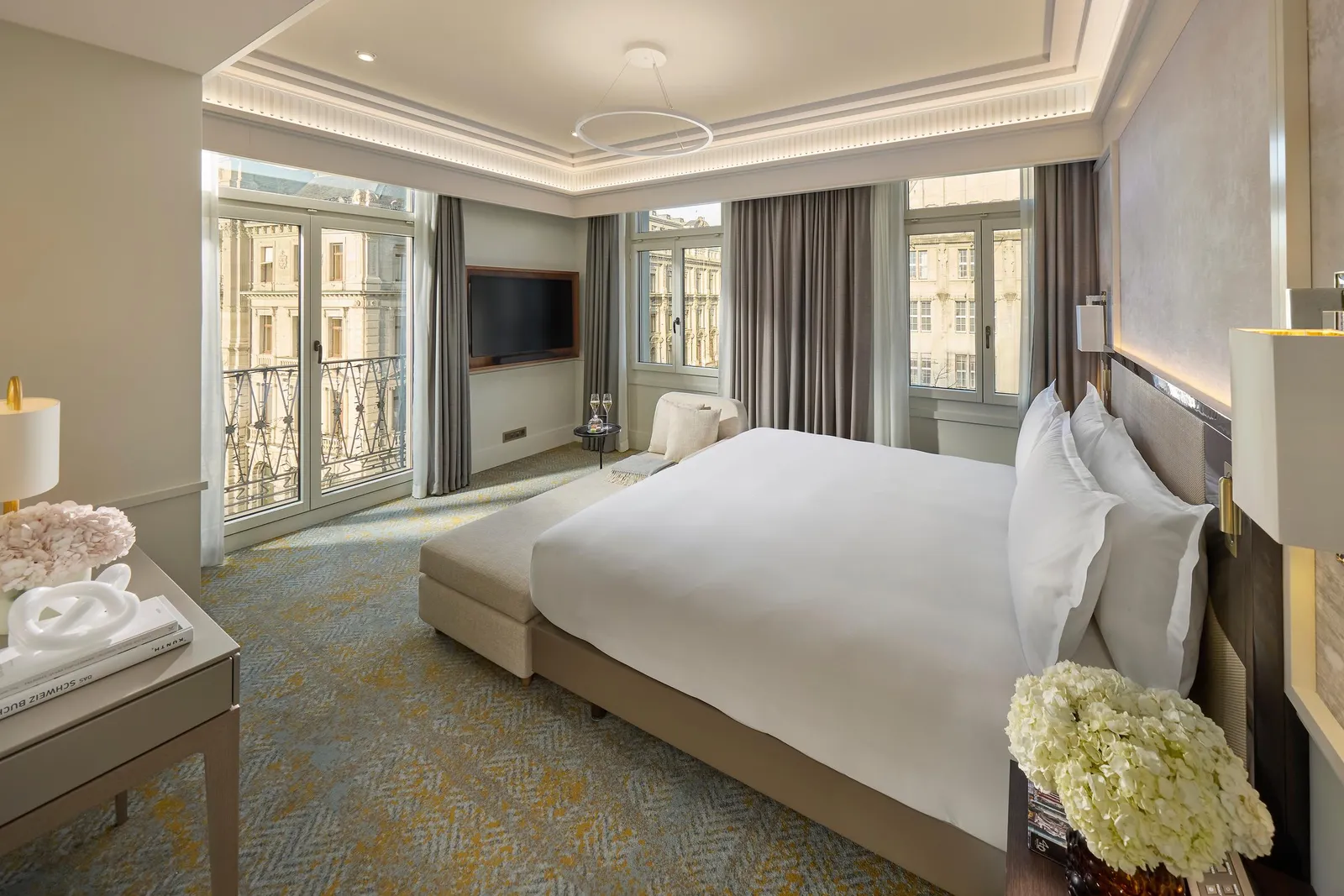 Bed and small table by the Corner Suite windows