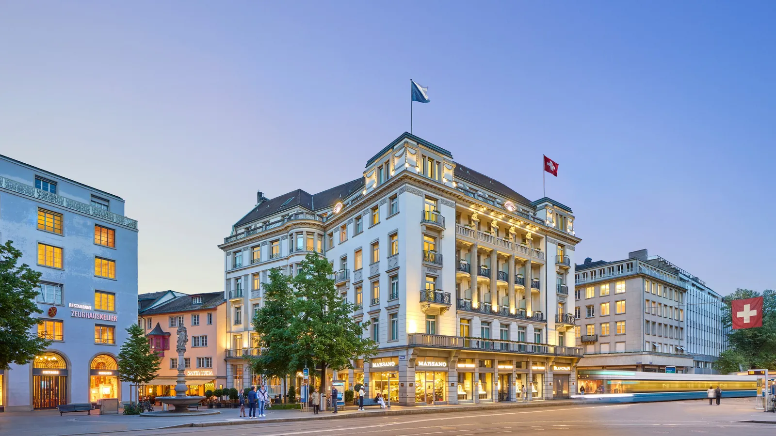 The illuminated Savoy façade on Paradeplatz at dusk