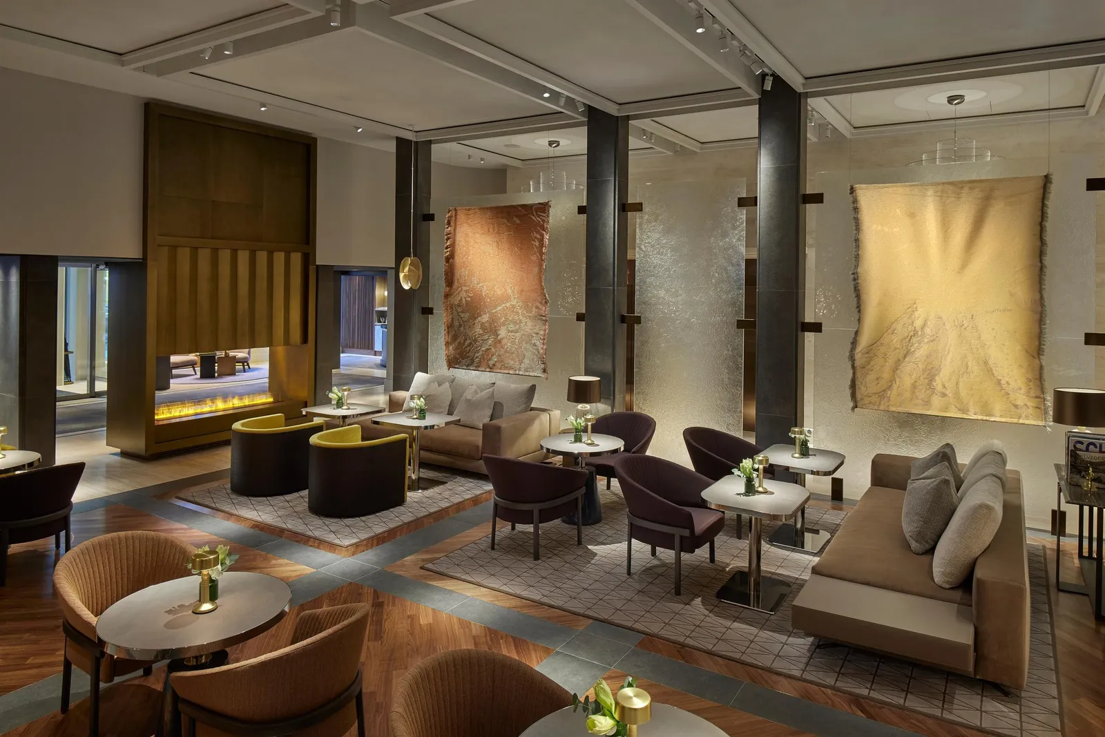 Poltrone, divani e tavoli nel Mandarin Lounge davanti al camino