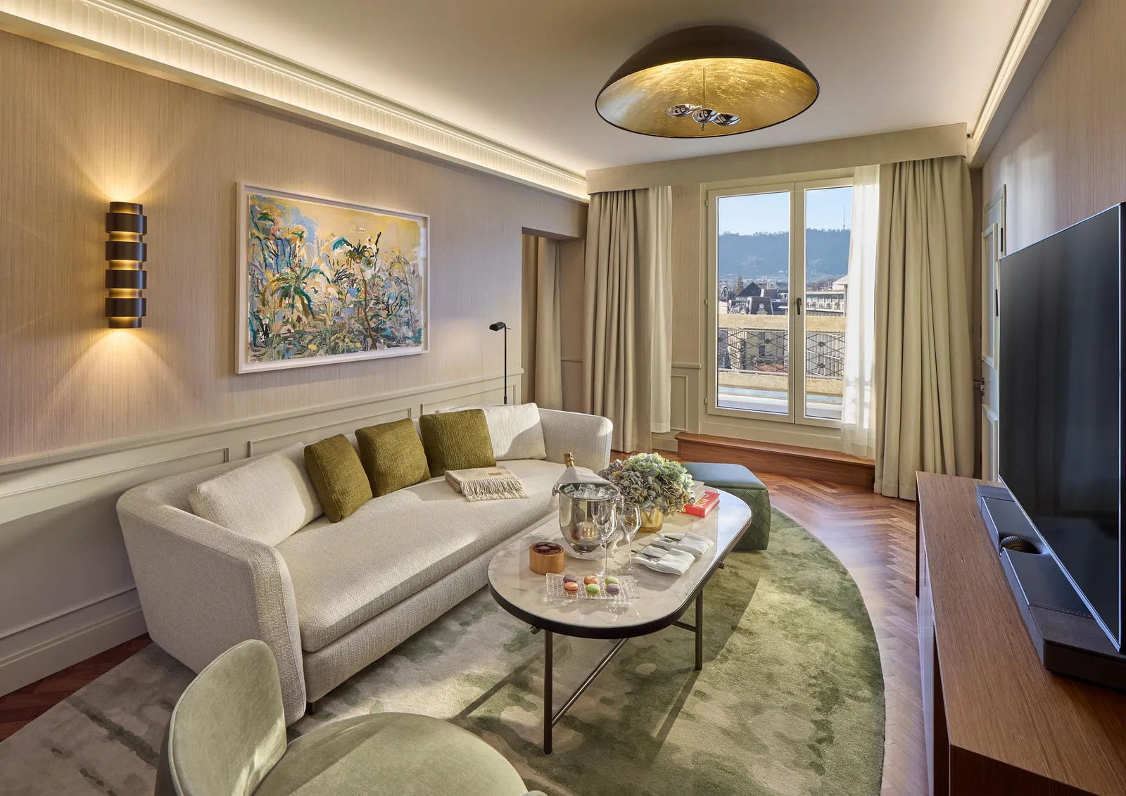 Green sofa and round table in the Grand Corner Suite
