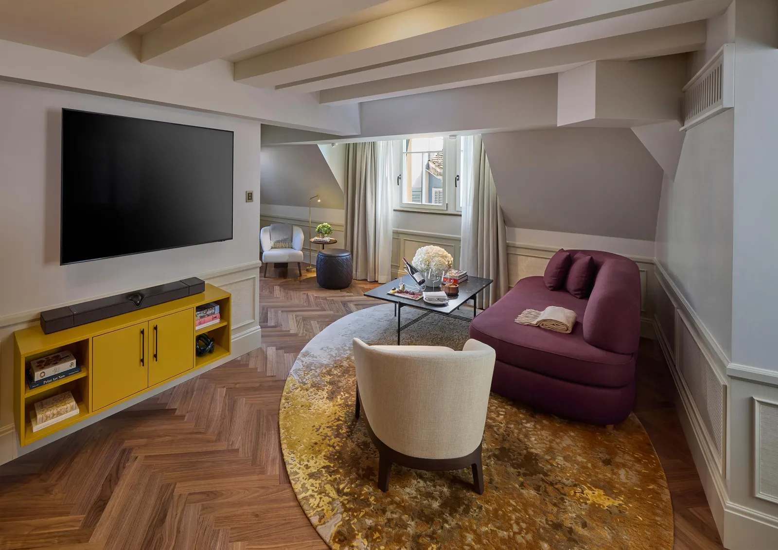 Purple sofa and television in the Orsini Suite