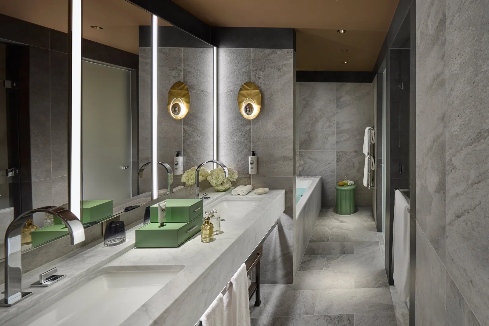 Marble bathroom with a bathtub and double vanity in the connecting suite