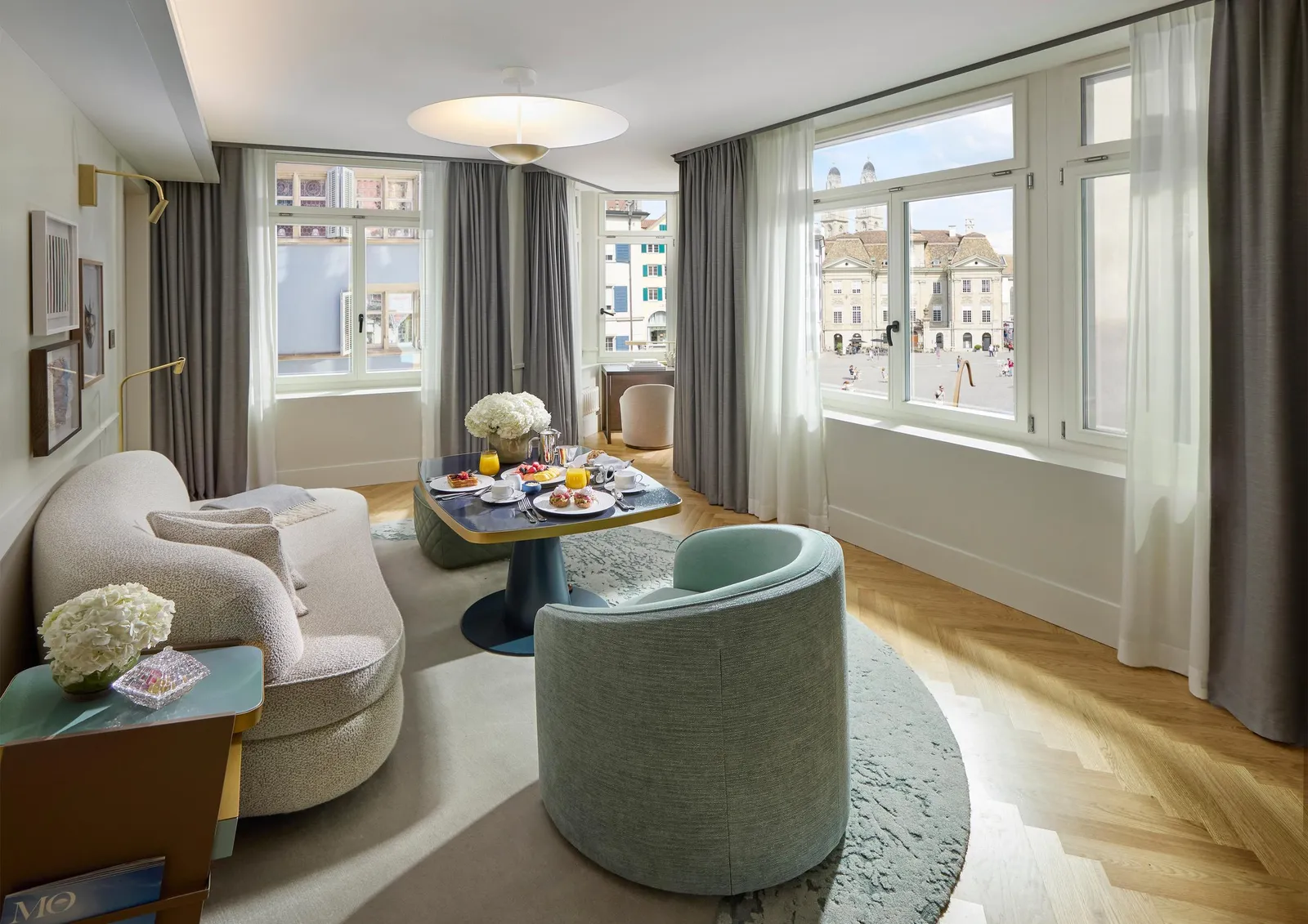 2 green armchairs and a small table by the suite windows