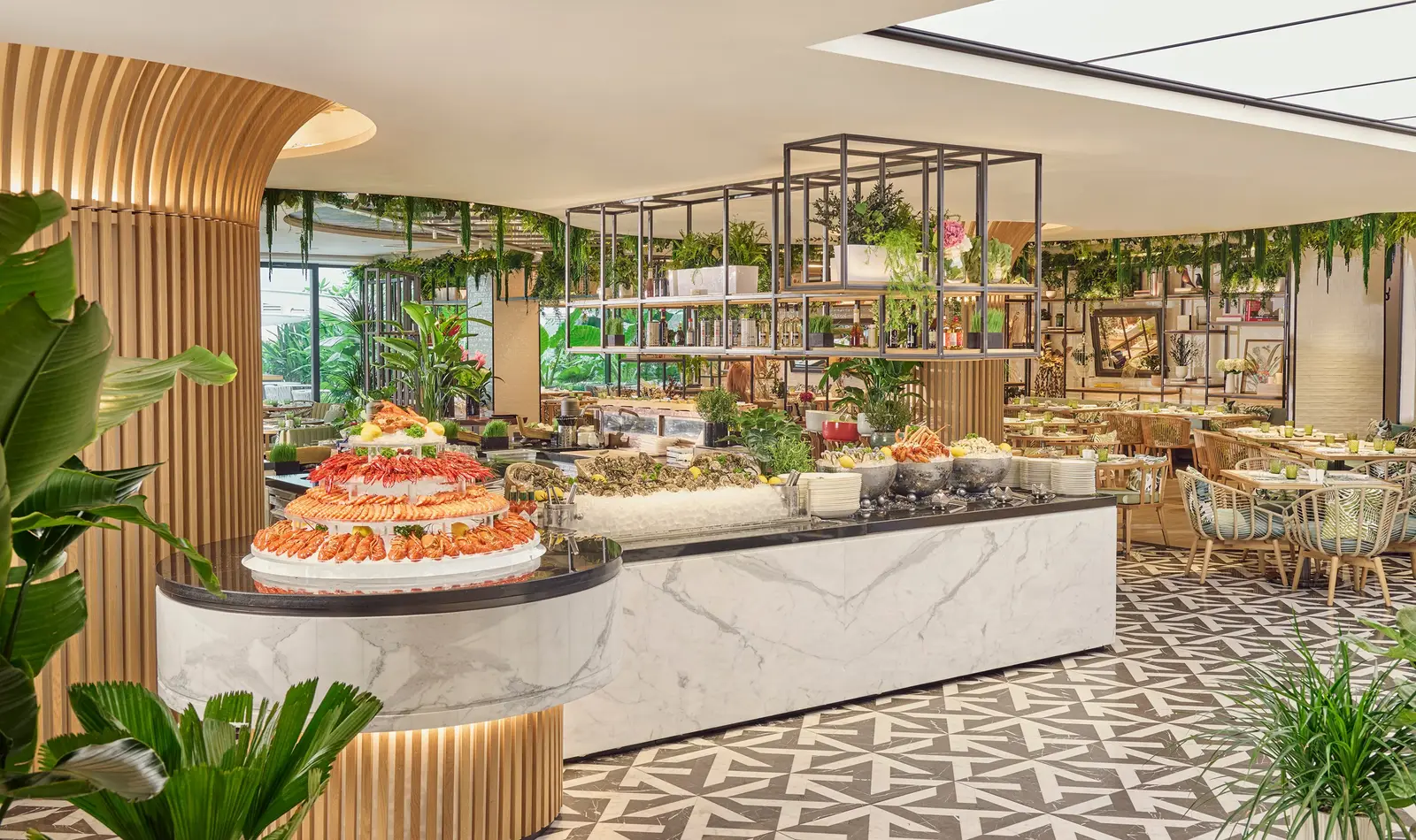 embu’s buffet: a pyramid of prawns and shellfish on ice on a marble counter, among slatted wooden columns and plants.
